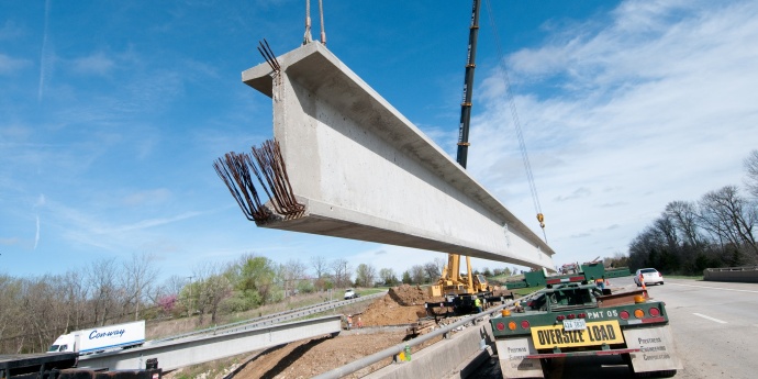 bridge construction image of a beam being lifted into place during construction