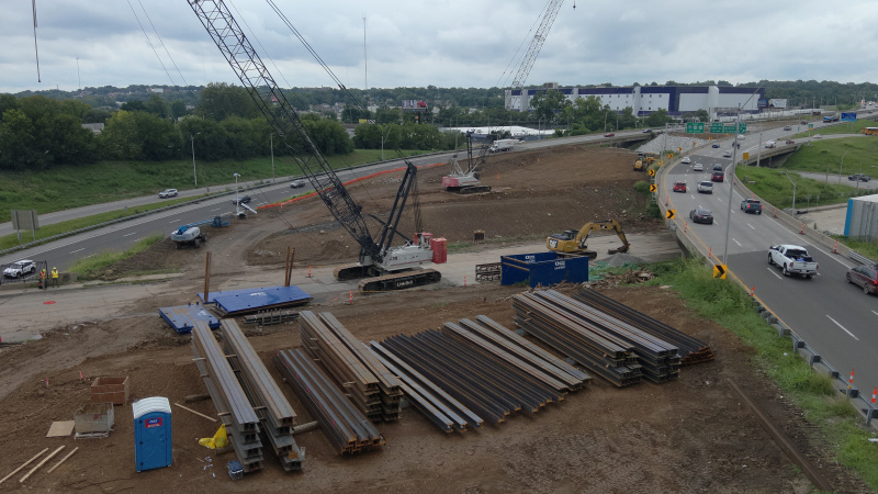 Stacks of bridge piling in dirt median of active interstate